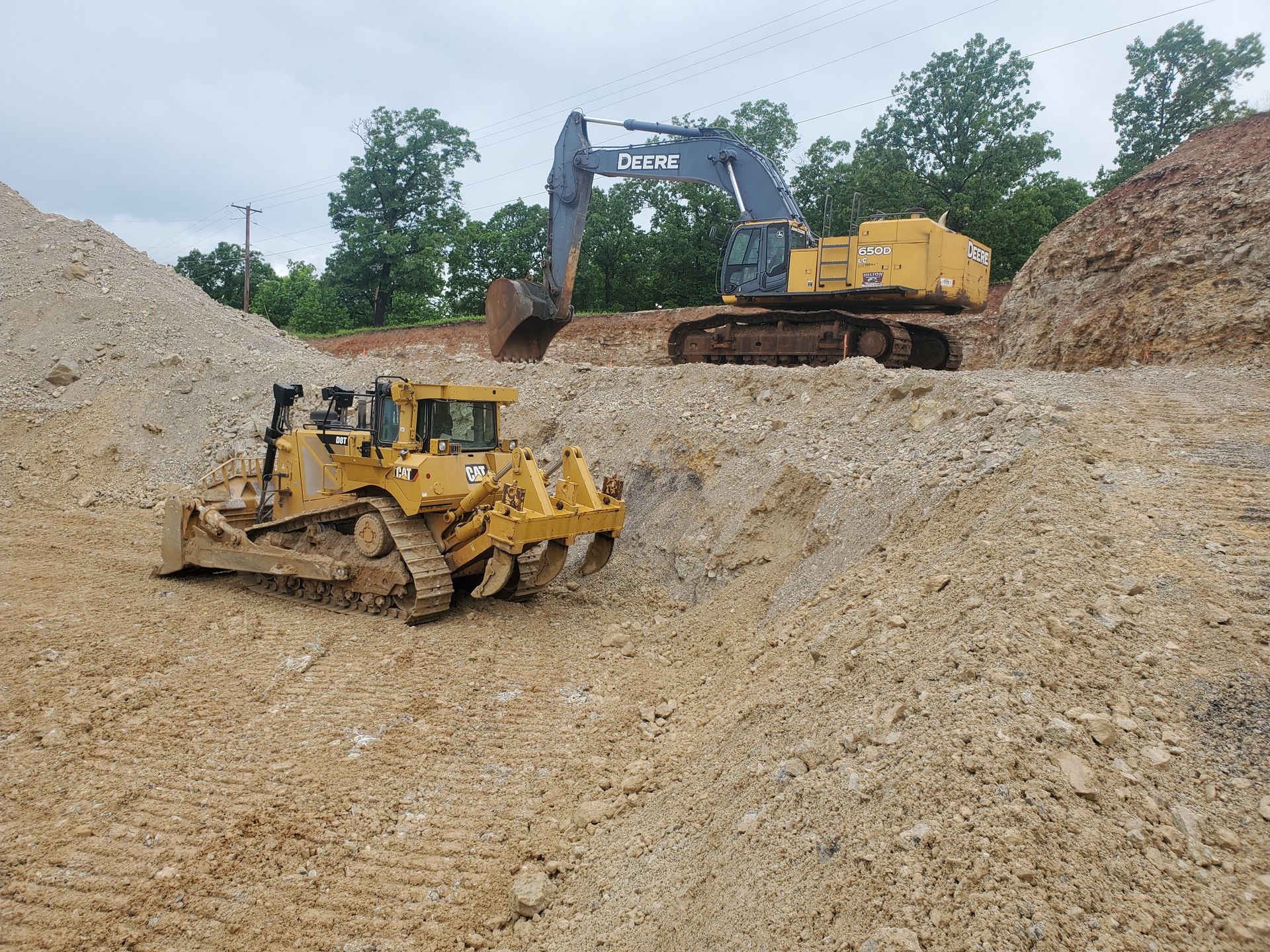 a yellow excavator is digging a hole in the ground .