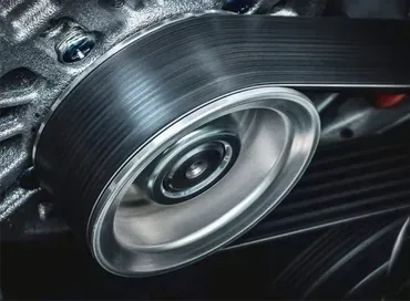 A man is holding a clutch disc in his hands.