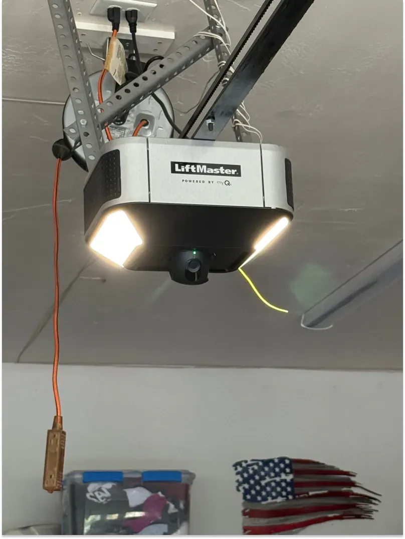 Garage door opener with lights and camera mounted on ceiling.