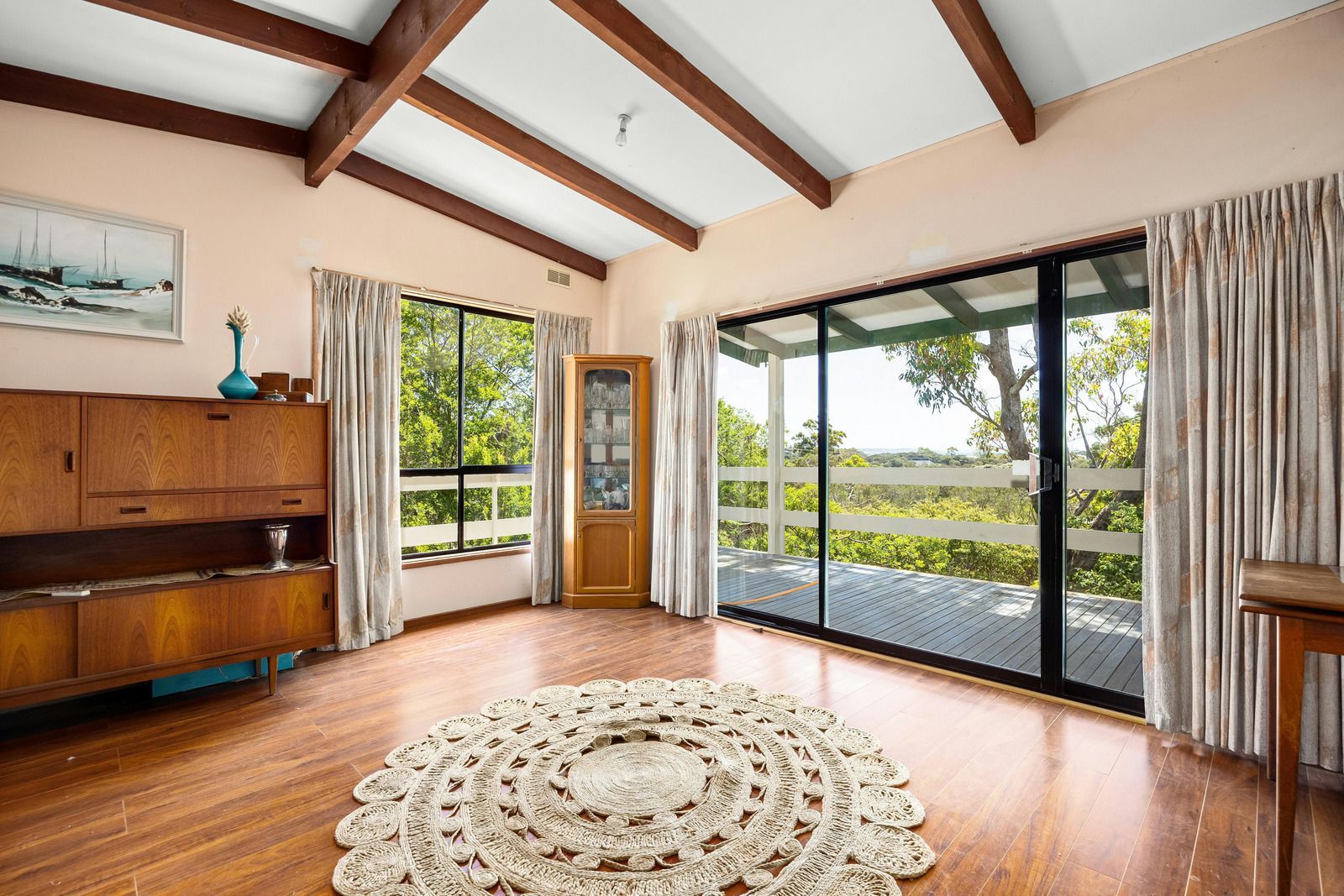 Building with a large reflective glass door, reflecting trees and sky. Construction site.