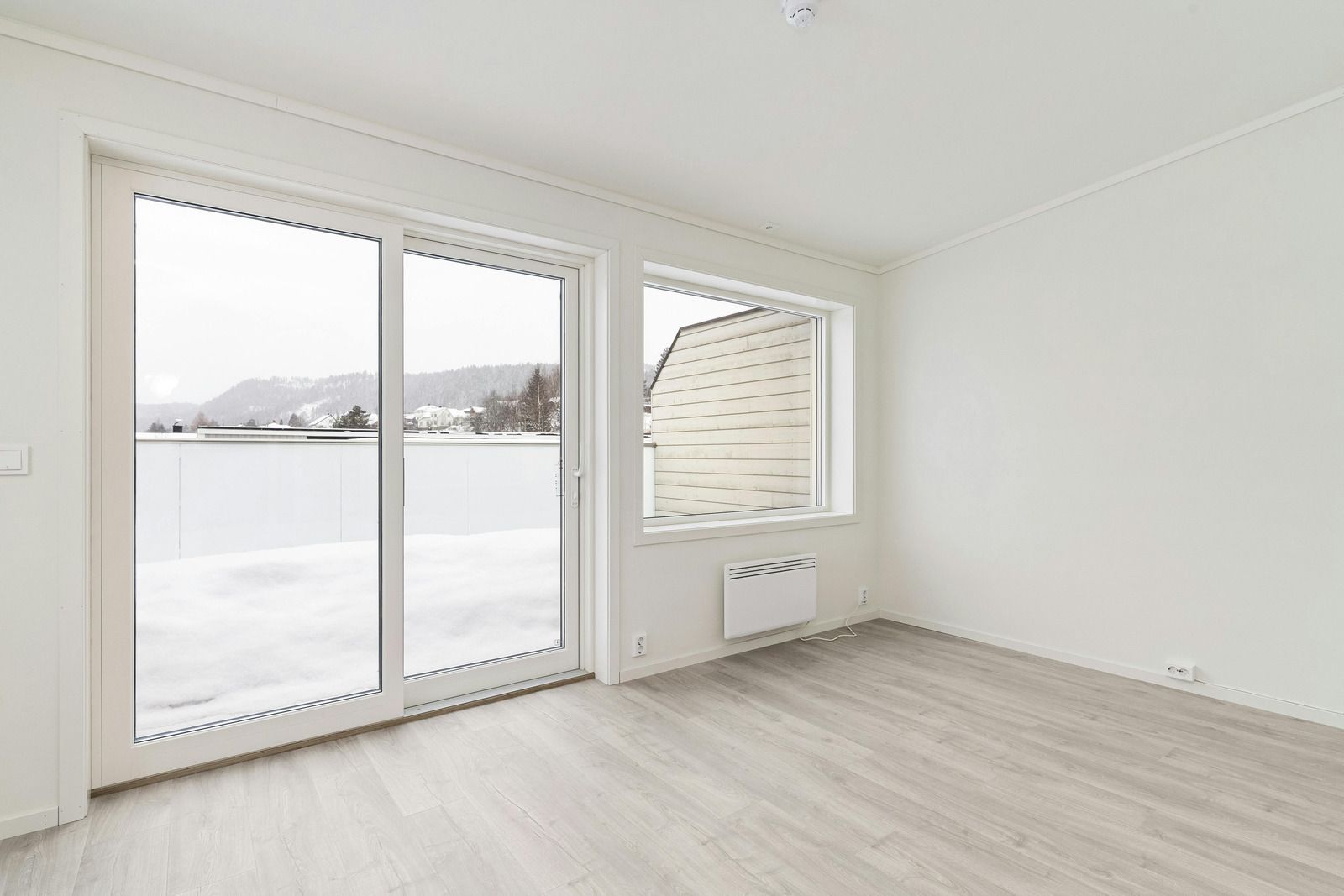 Garage door with horizontal glass panels set in a white building. Construction debris visible nearby.