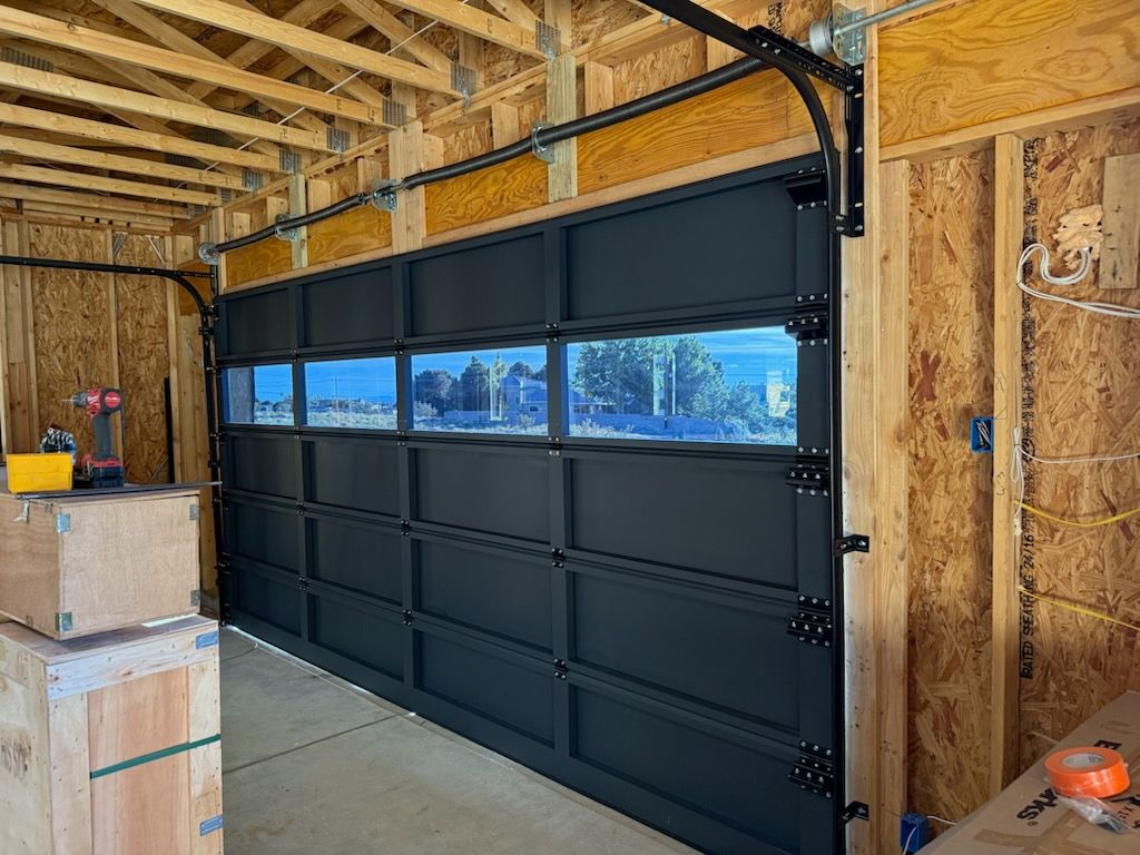 Black garage door with multiple rectangular windows, interior view.