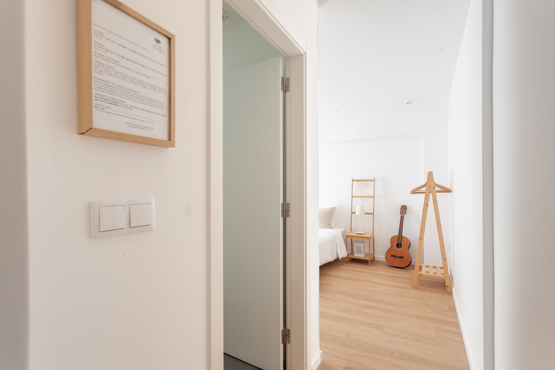 a hallway leading to a bedroom with a guitar on the wall .