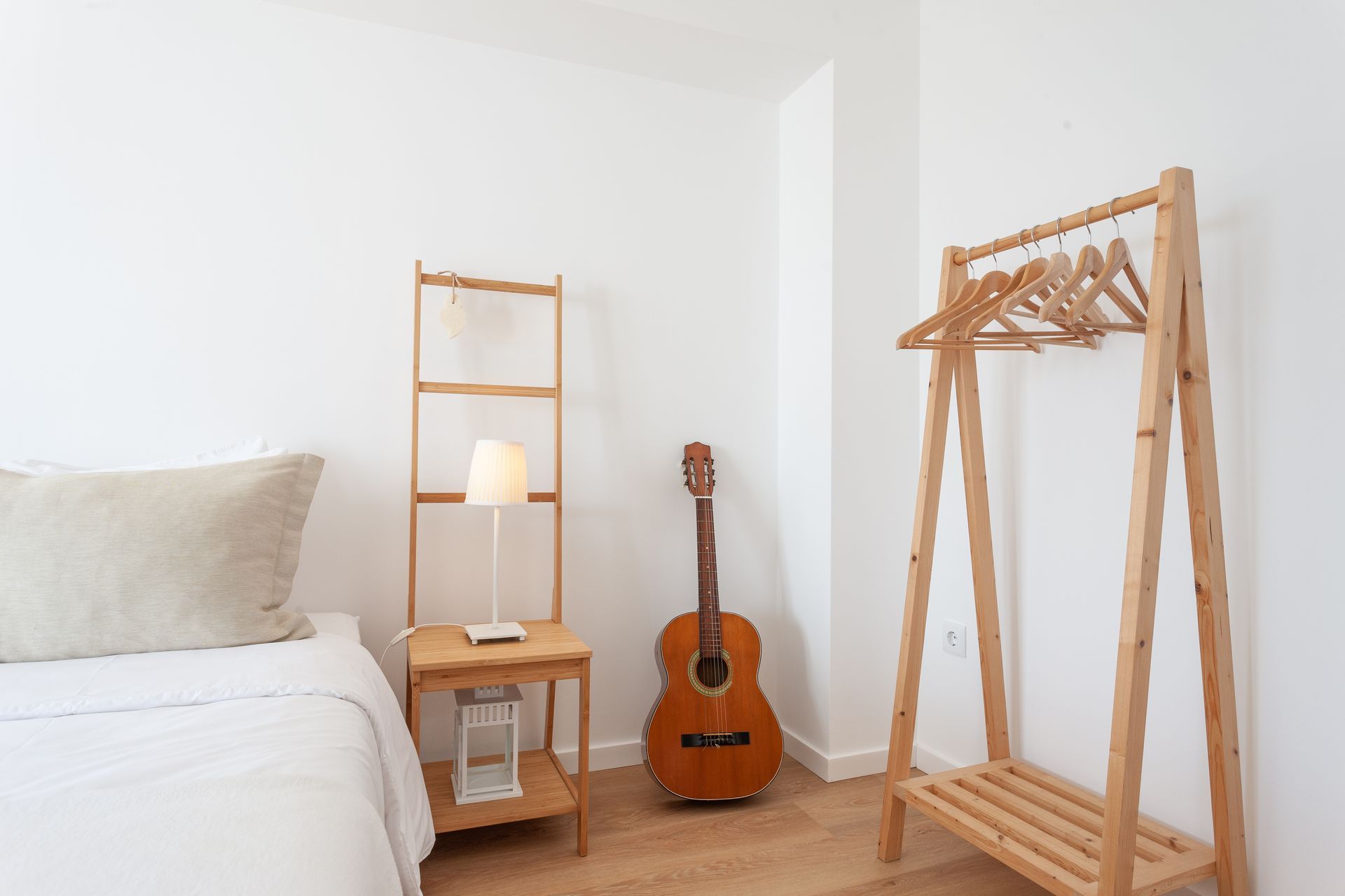 a bedroom with a bed , nightstand , lamp and guitar .