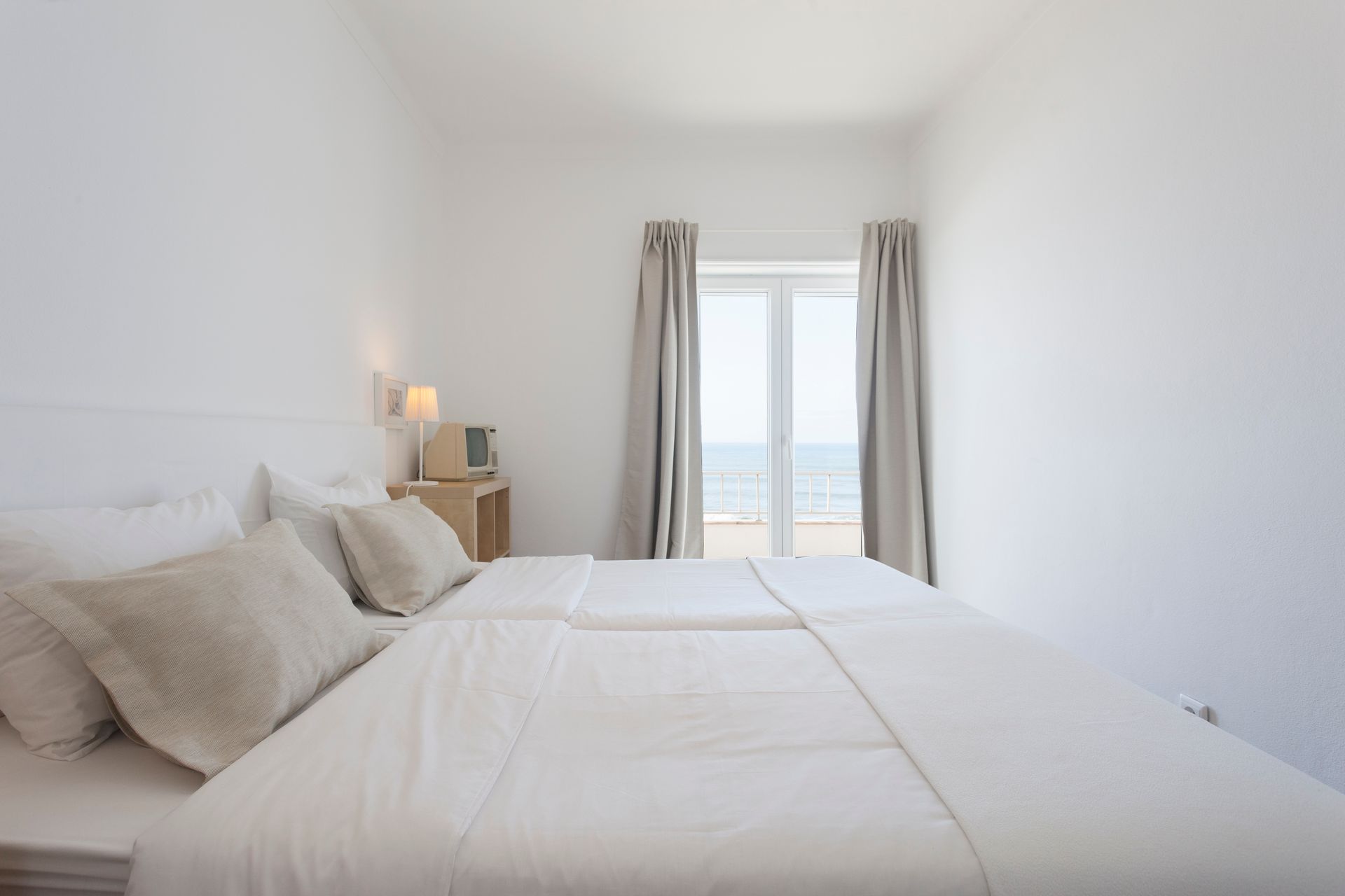 a bedroom with a bed and a window with a view of the ocean .