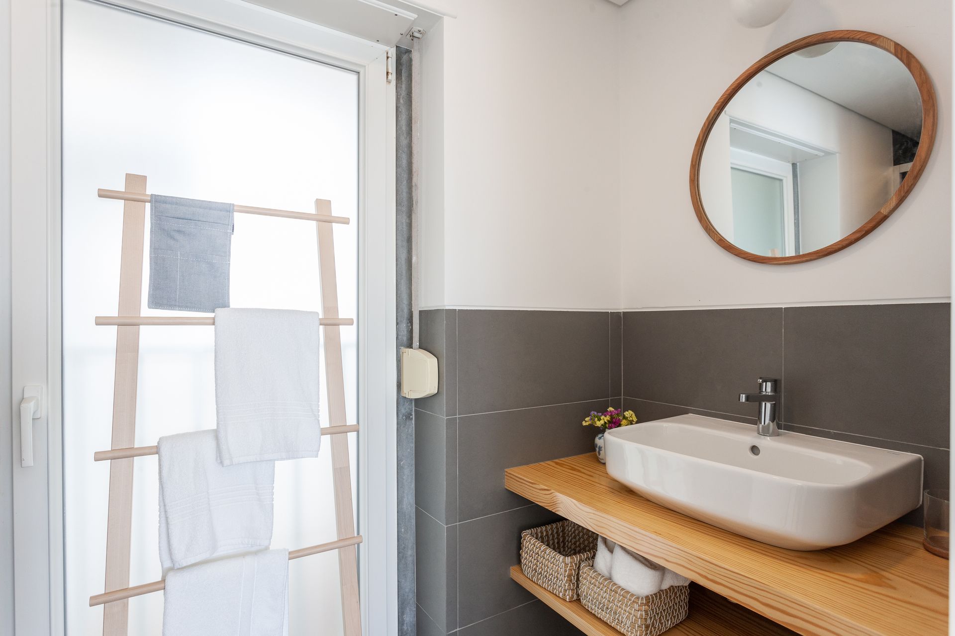 a bathroom with a sink , mirror and towel rack .