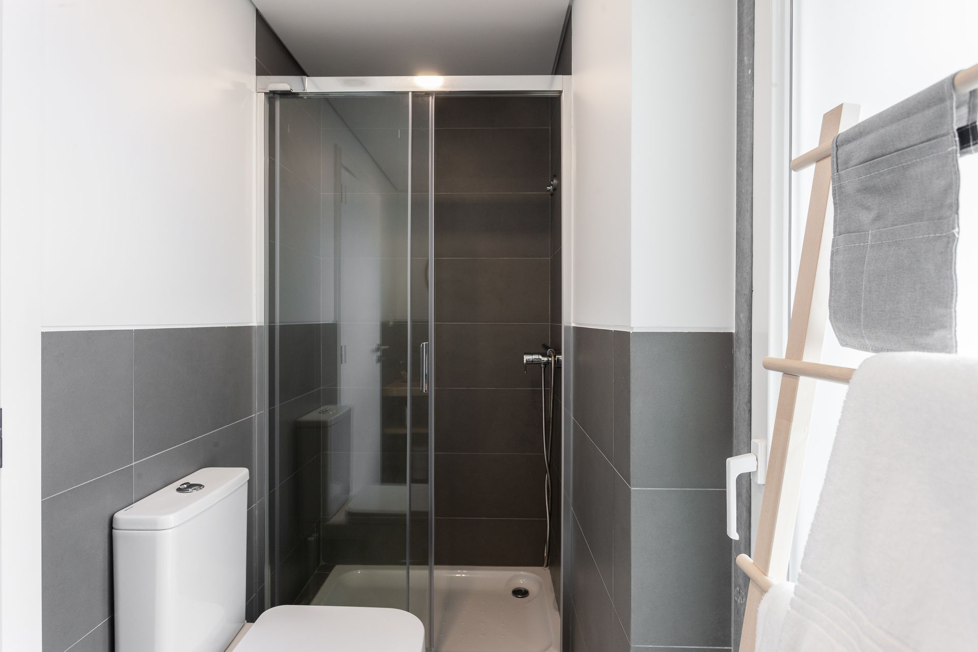 a bathroom with a toilet , shower and towel rack .