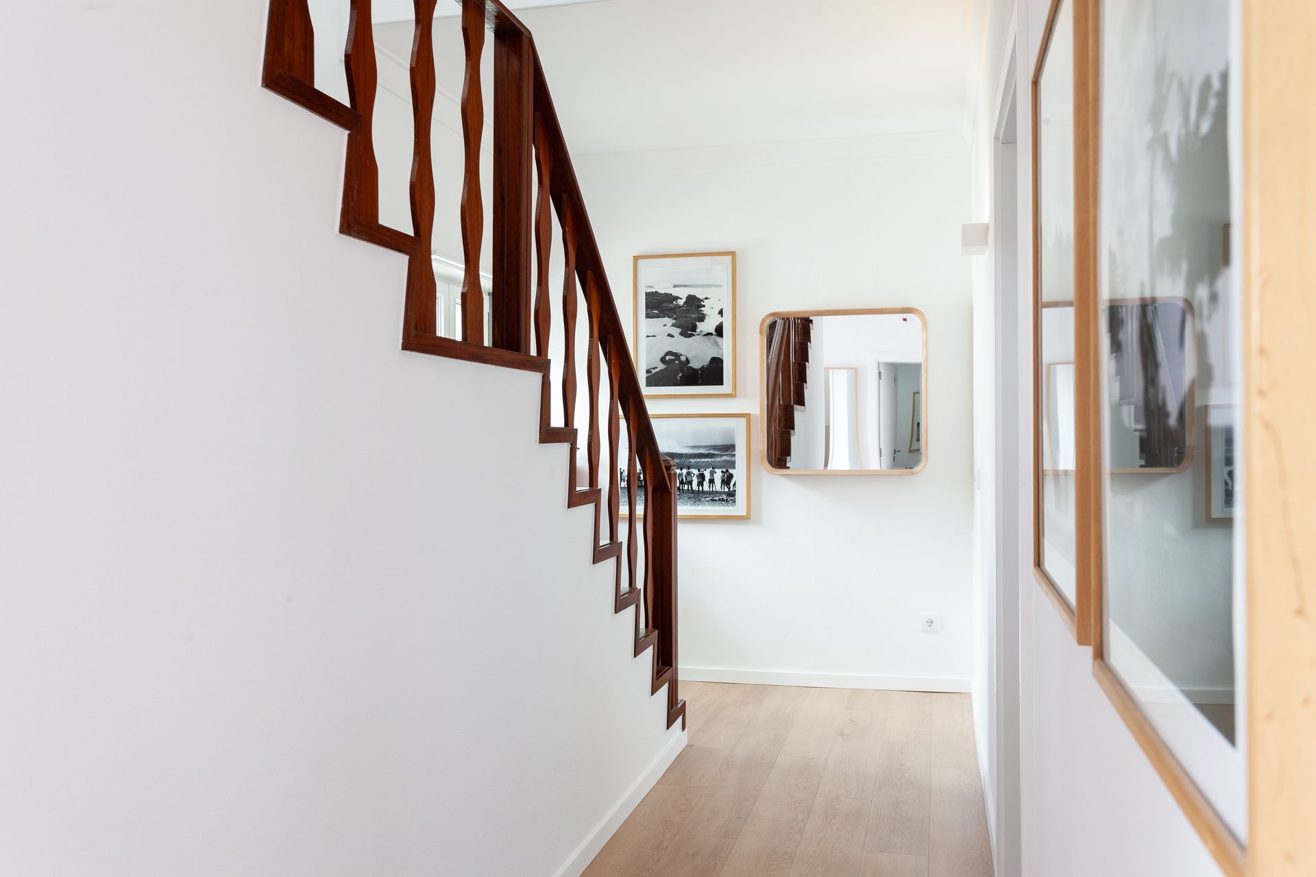 a hallway with stairs and pictures on the wall