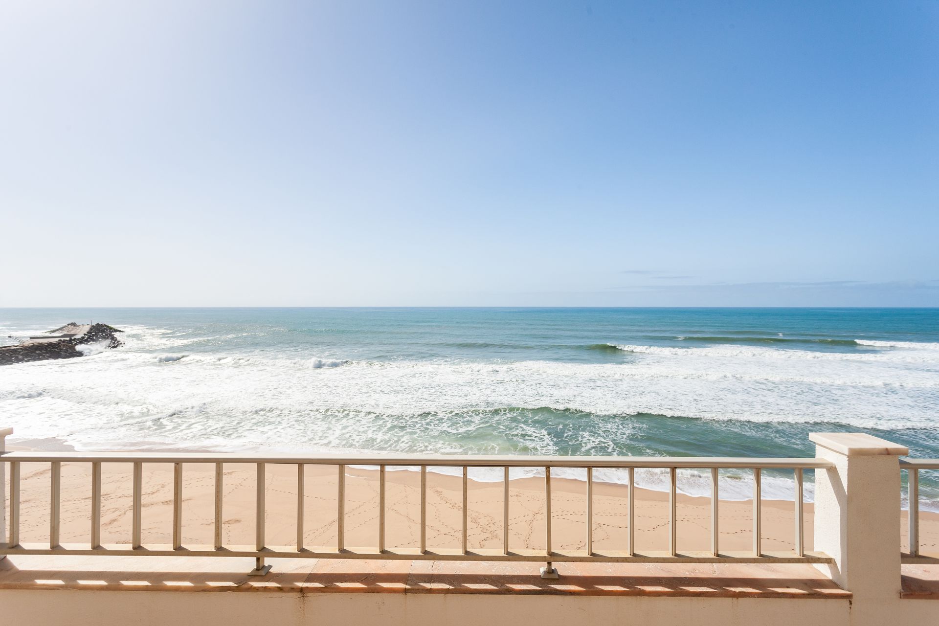 a view of the ocean from a balcony with a railing