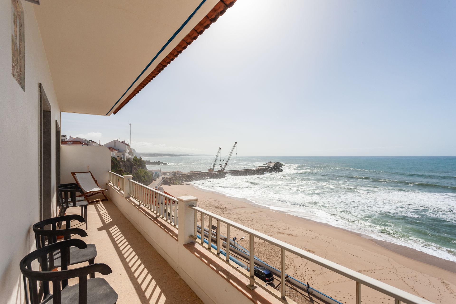 a balcony with chairs and a view of the ocean