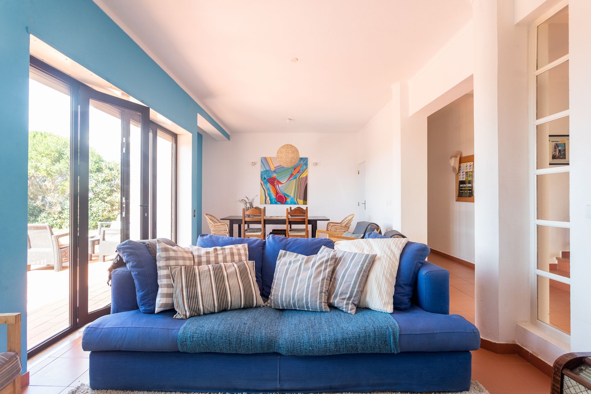 a living room with a blue couch and lots of windows