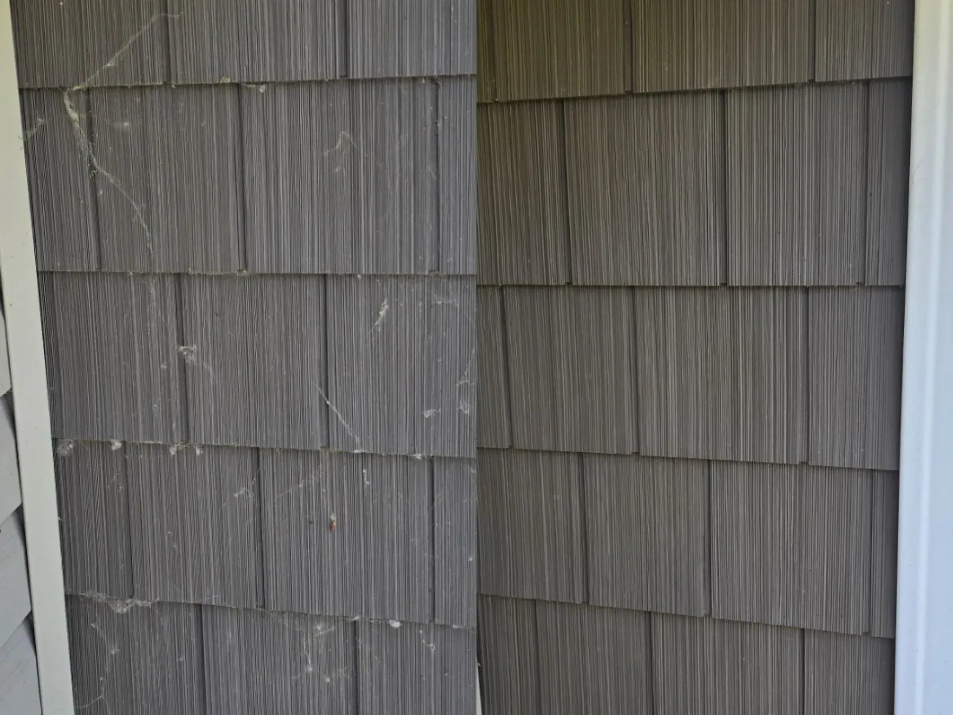 A close up of a siding on a house with a white trim.