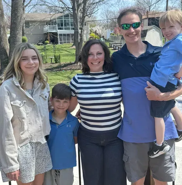 A group of people posing for a picture including a man holding a child
