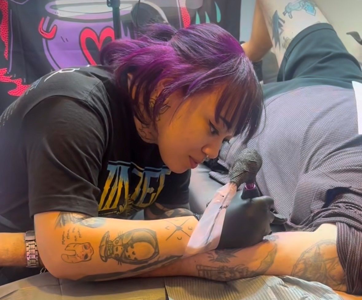 Custom tattoo artist tattooing an arm