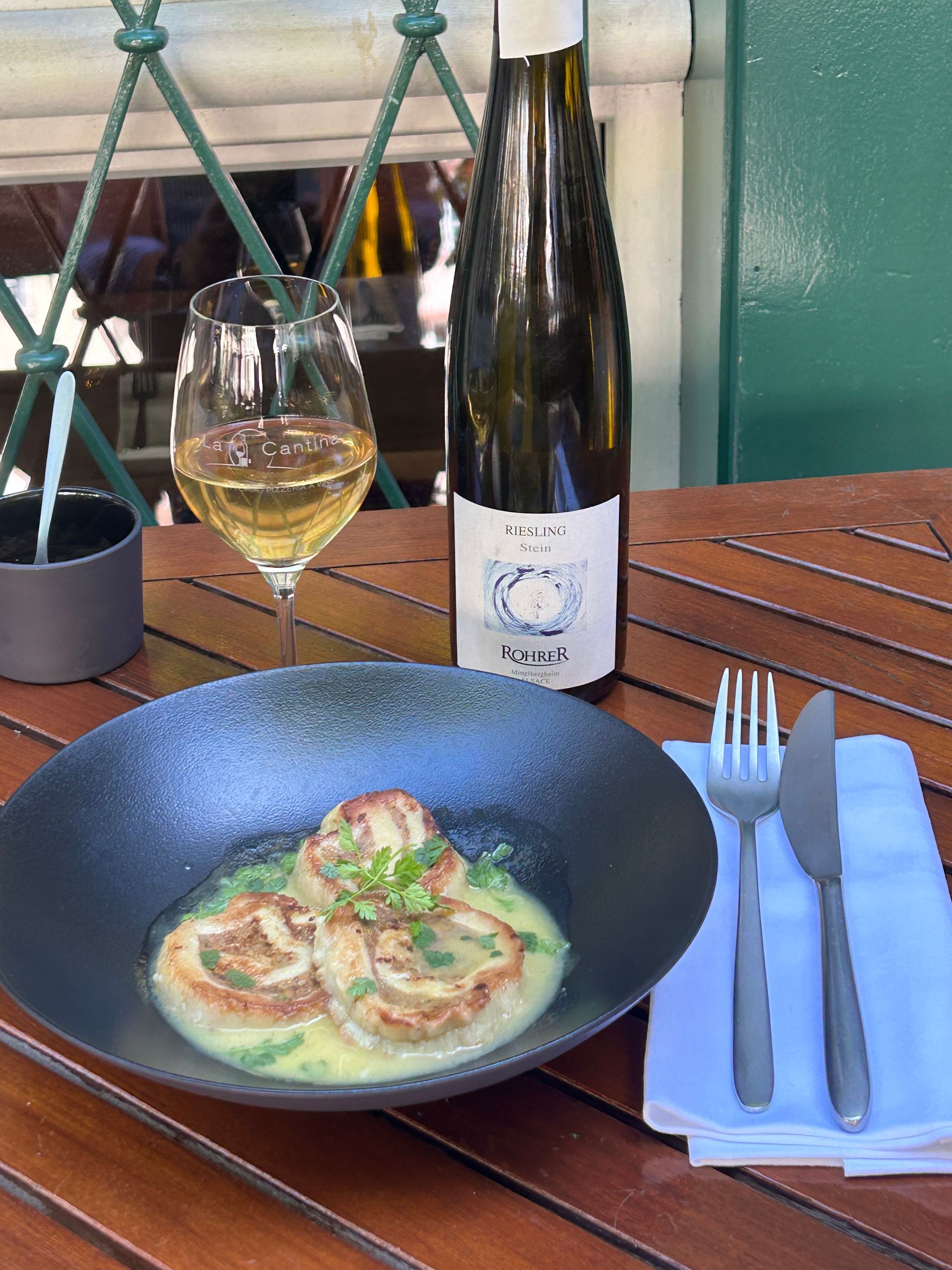 Une bouteille de vin et une assiette de nourriture sur une table