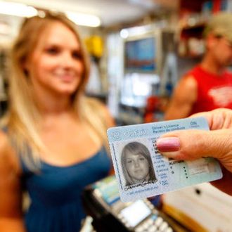 A female is presenting her ID to purchase alcohol at a retail alcohol establishment.
