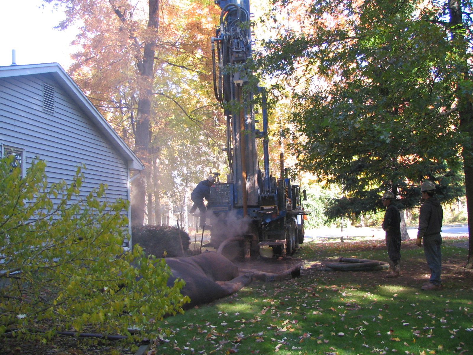 a man is standing in front of a drill in a yard