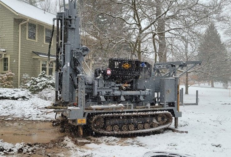 a machine is sitting in the snow in front of a house .
