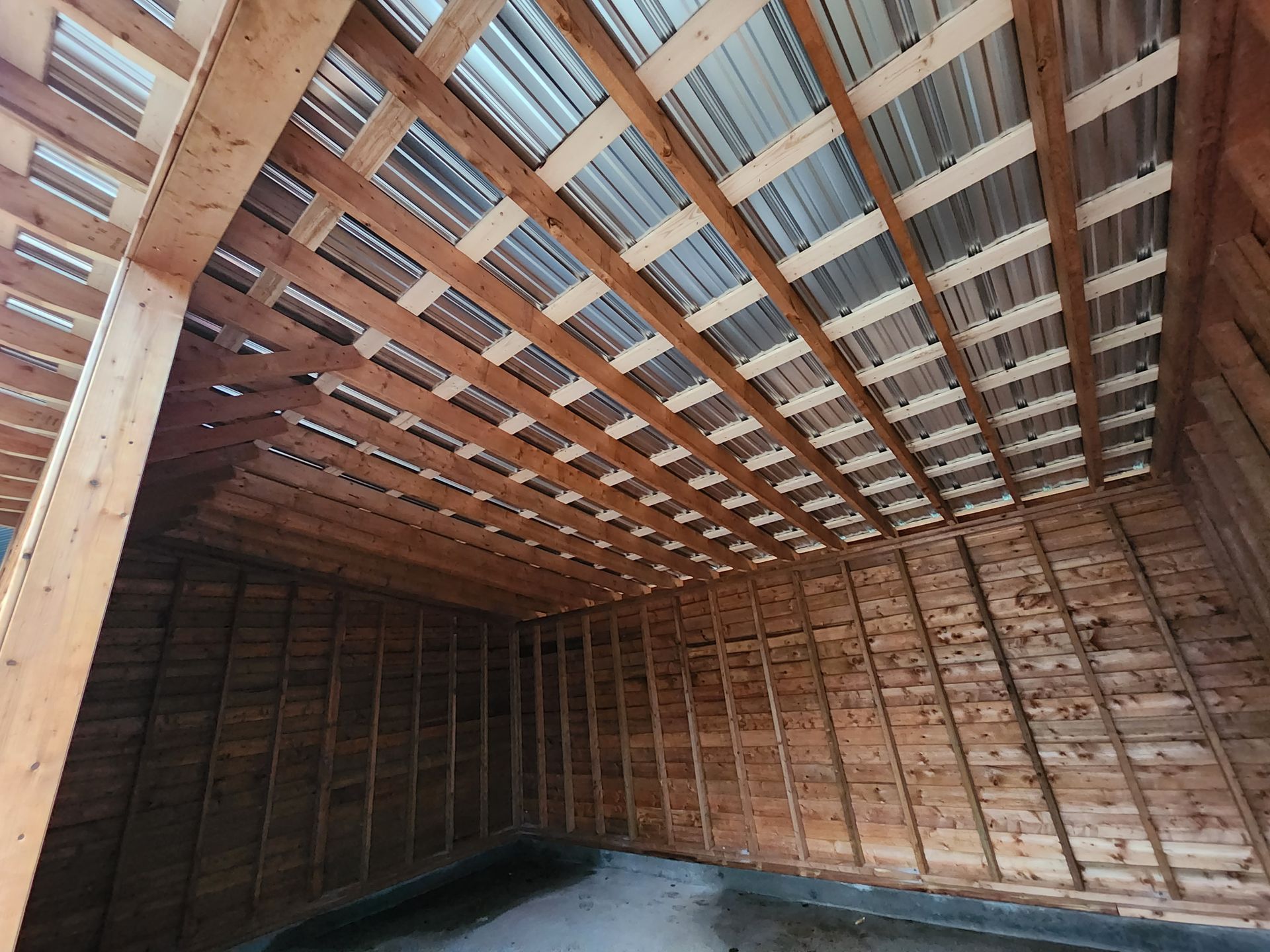 L'intérieur d'un bâtiment en bois avec un toit en métal