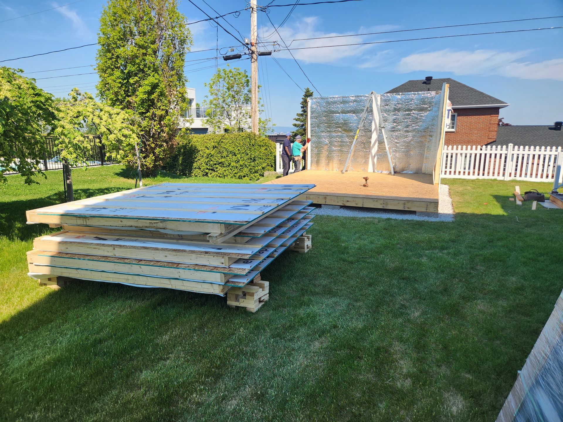 Une pile de planches de bois est posée sur une pelouse verte luxuriante.