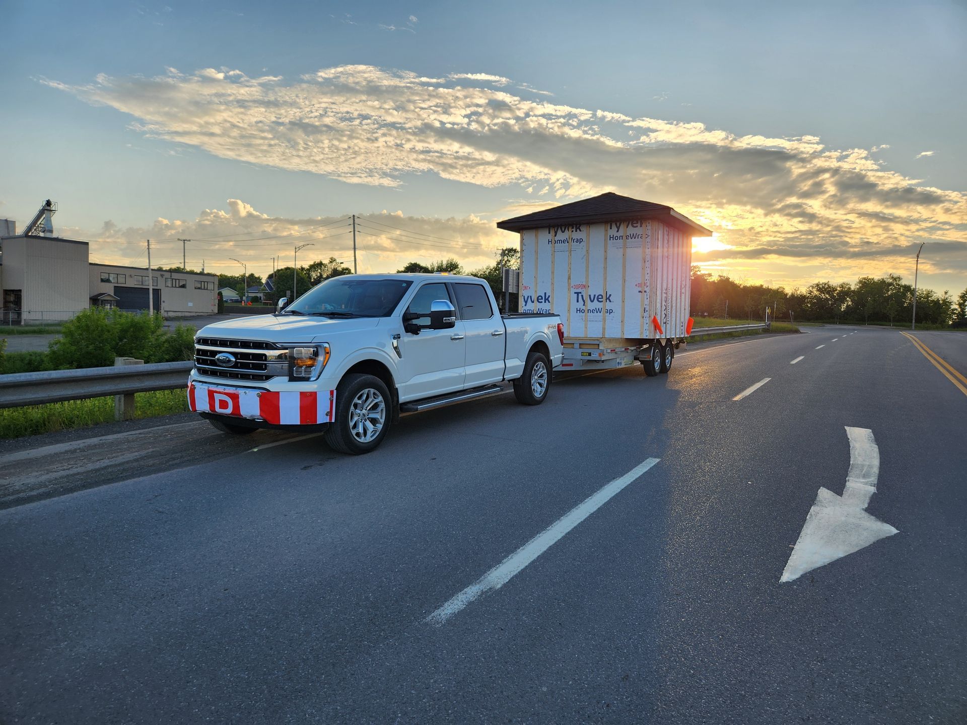 Un camion blanc tire une remorque sur une autoroute.