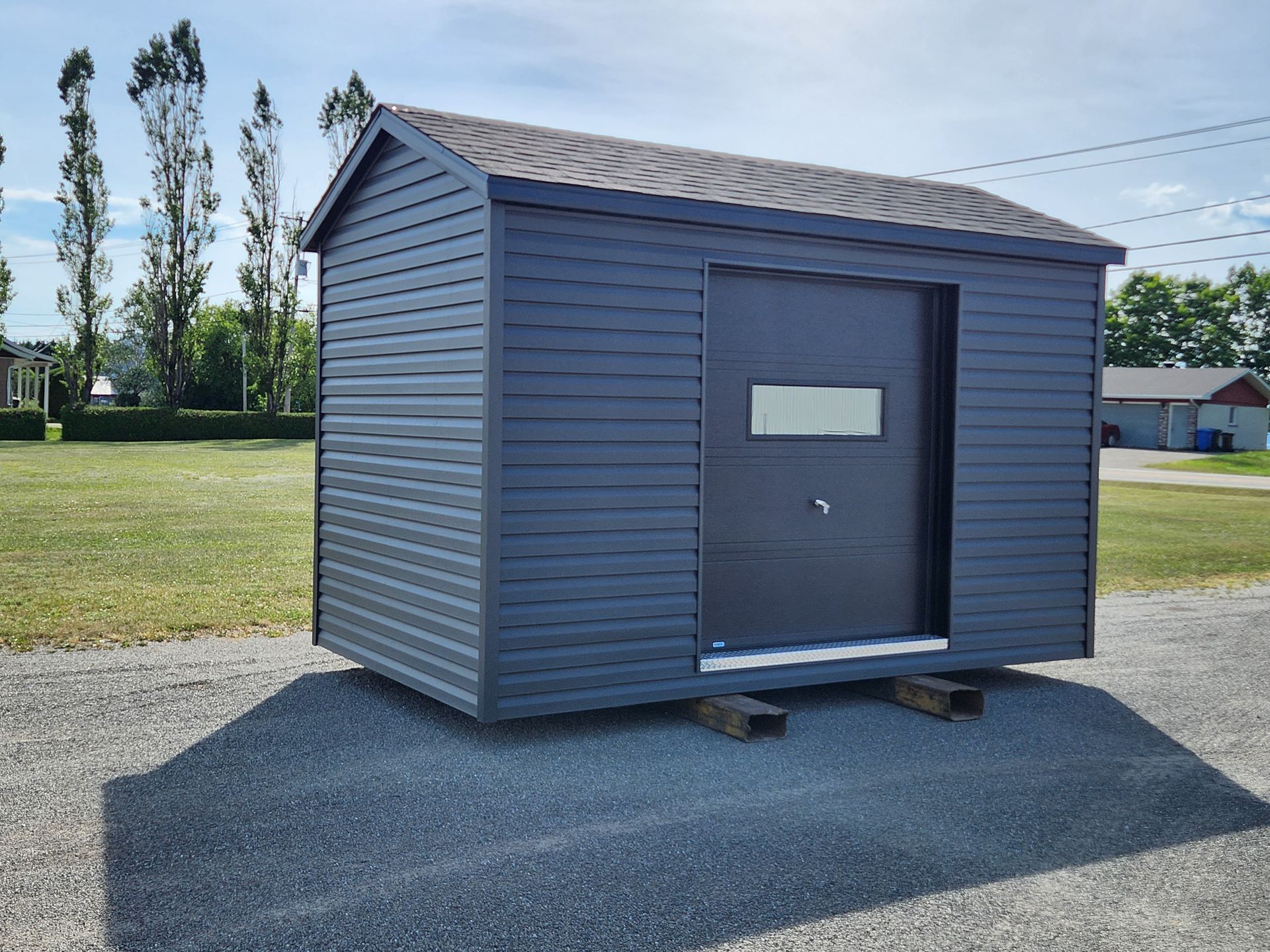 Un petit hangar est posé au sommet d'un chemin de gravier.