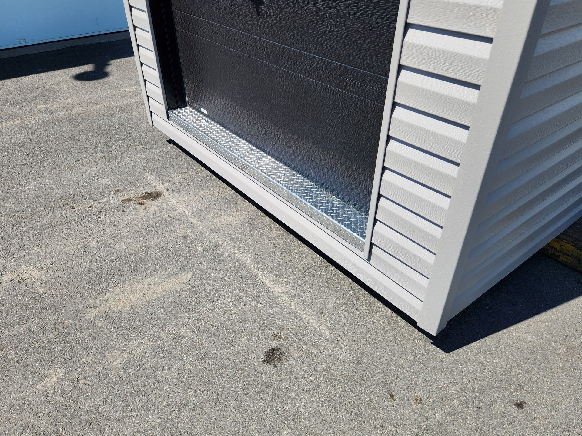 Un bâtiment gris et noir est assis sur le sol.