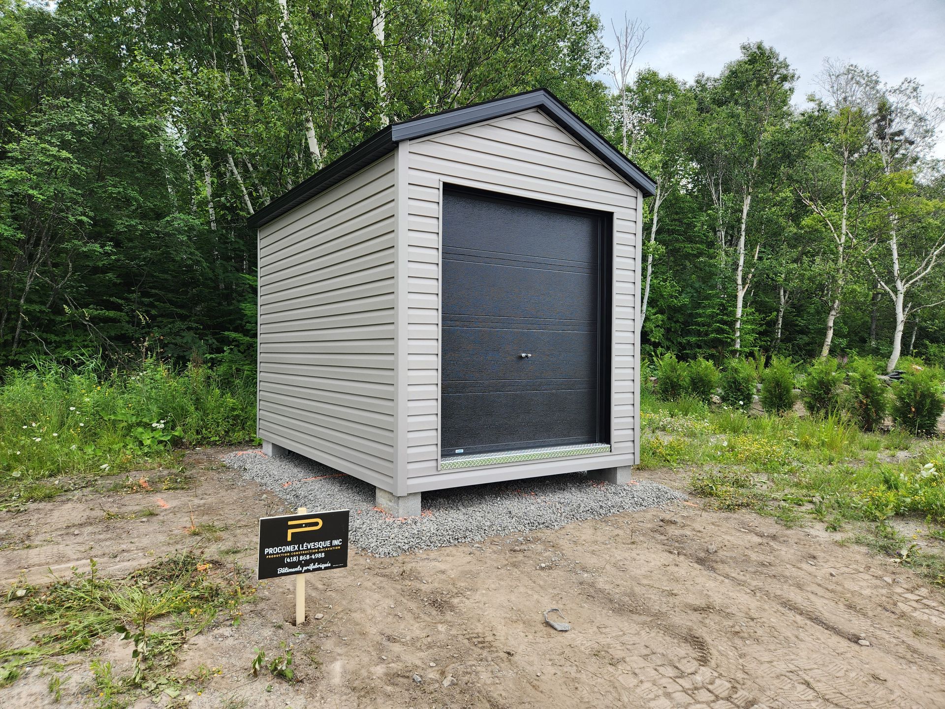 Un petit hangar se trouve au milieu d'un champ de terre.