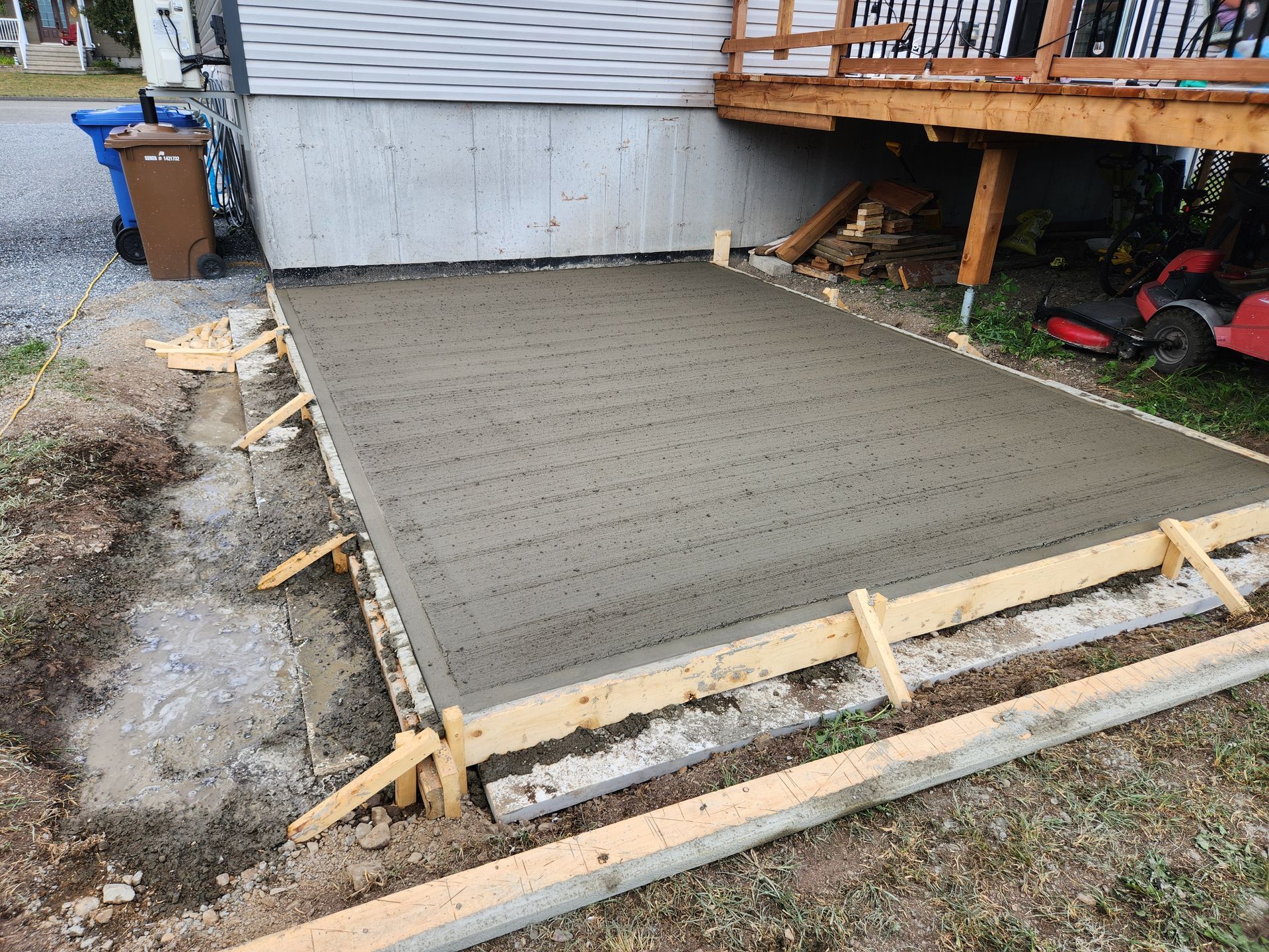 Une dalle de béton est en train d'être construite devant une maison.