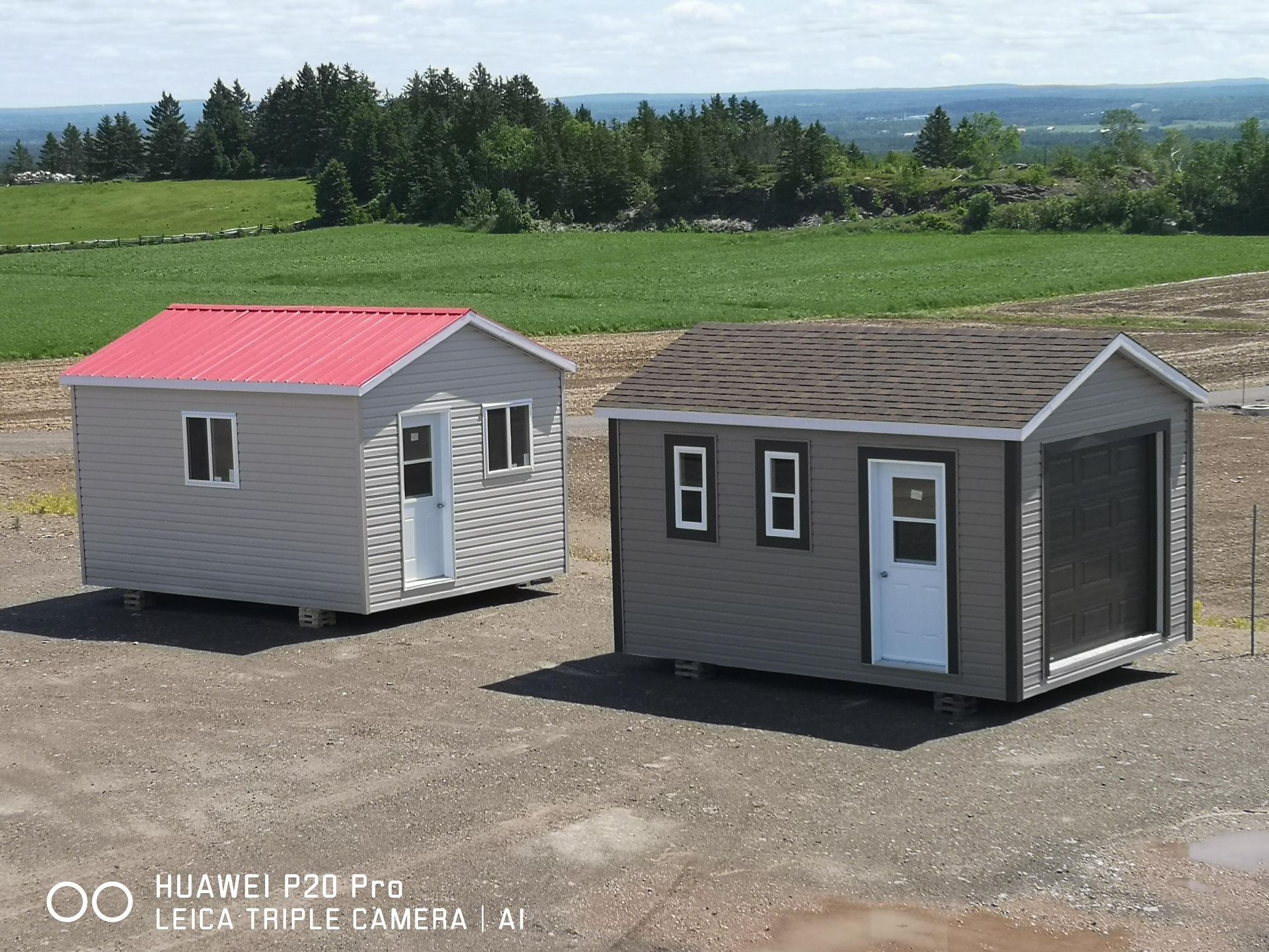 Deux hangars sont situés l'un à côté de l'autre dans un champ.