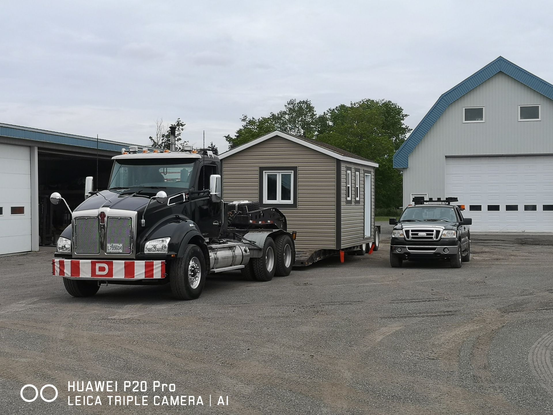 Un camion transporte une petite maison sur une remorque.