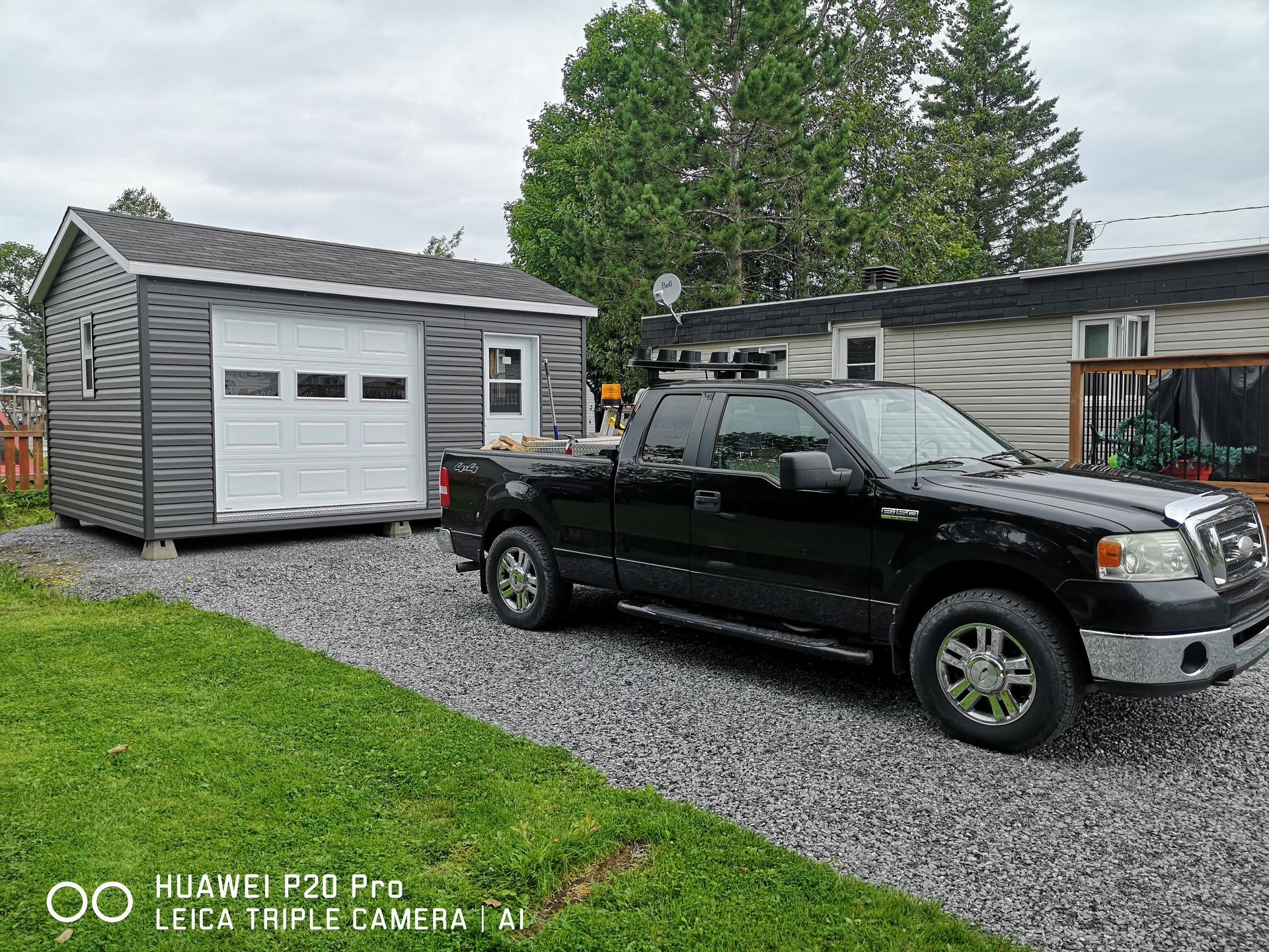 Un camion noir est garé devant un garage.