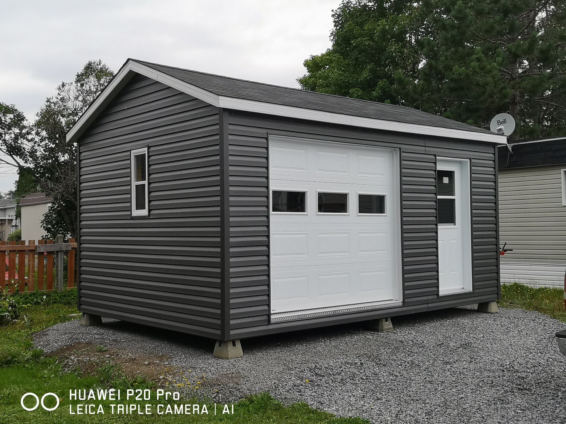 Un petit hangar avec une porte de garage et une fenêtre.