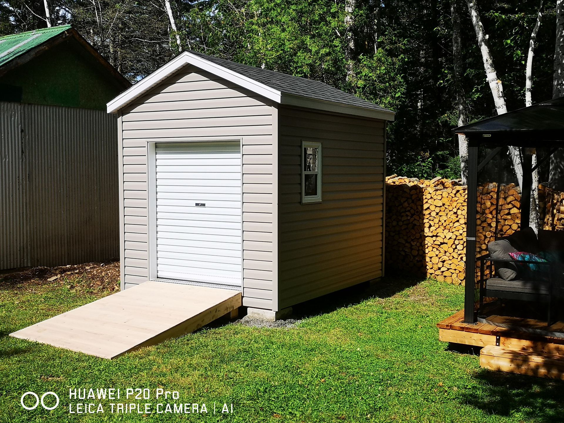 Un petit hangar avec une rampe dans la cour arrière.