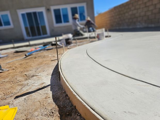 A concrete Patio is being built in back yard of a house in Beaumont, CA.