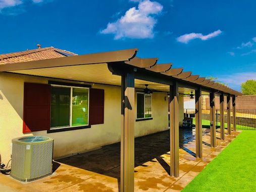 A house with a pergola and a air conditioner in the backyard.