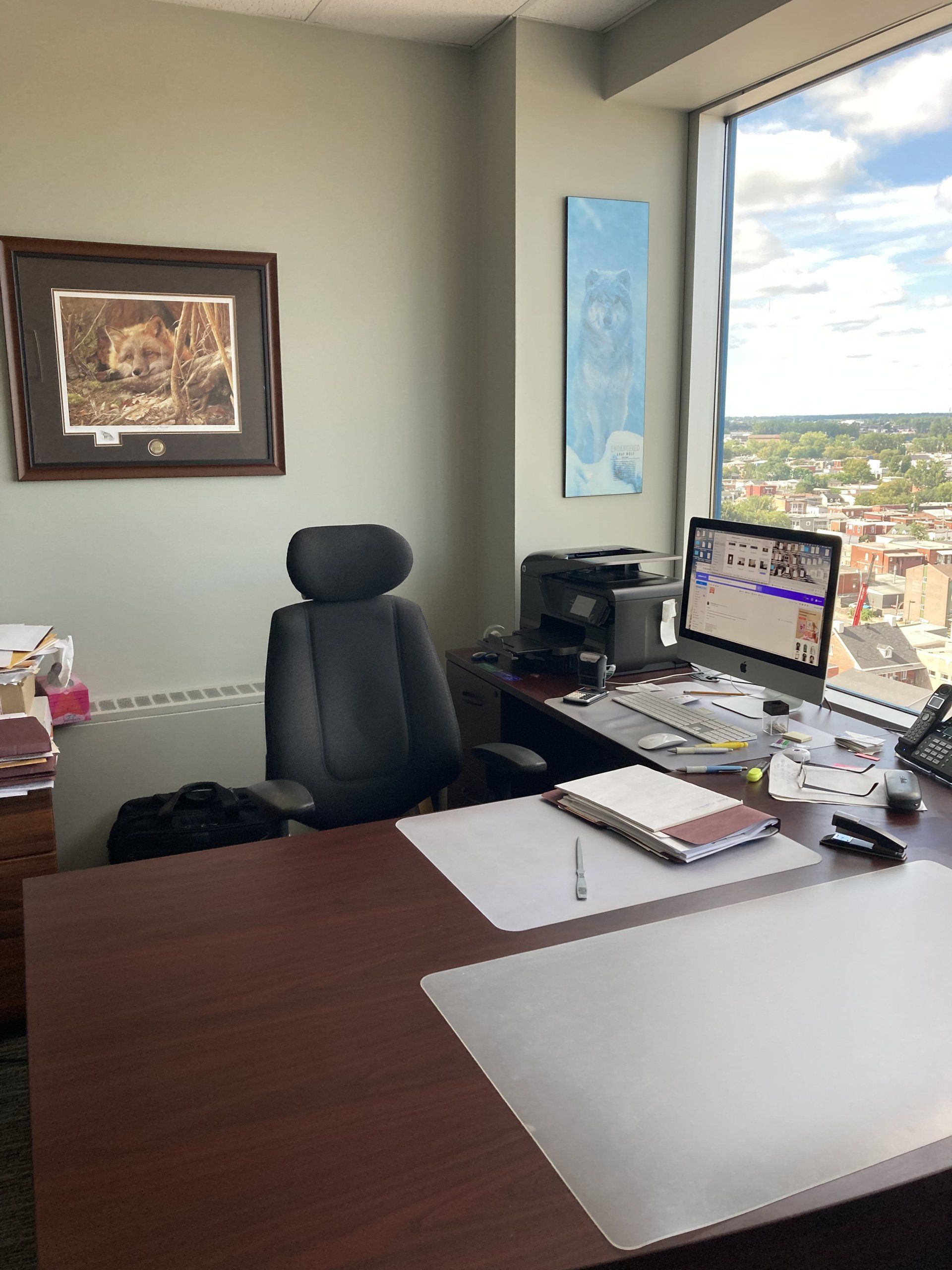 Un bureau avec un ordinateur et une photo au mur