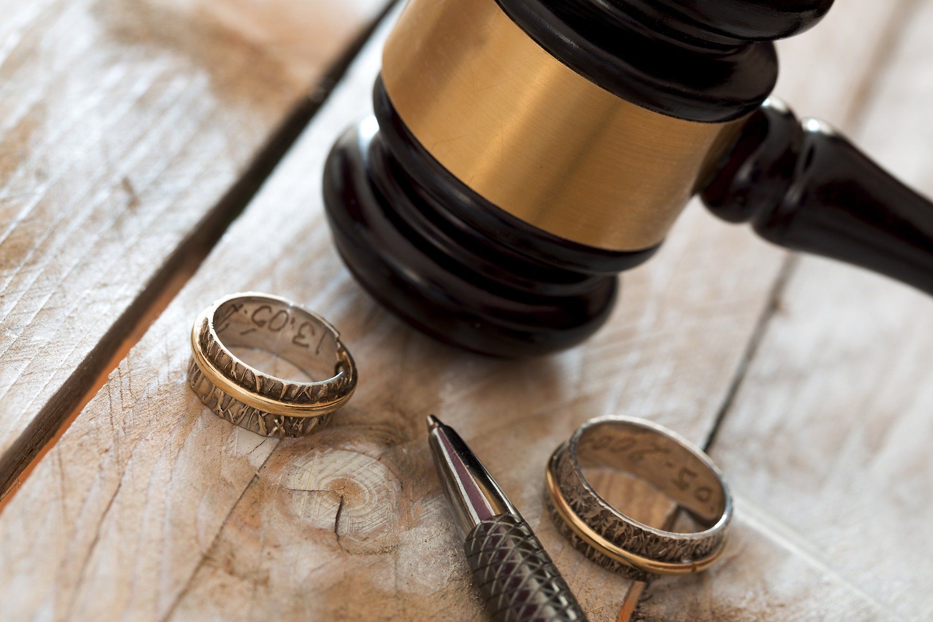 Une paire d alliances et un marteau de juge sur une table en bois.