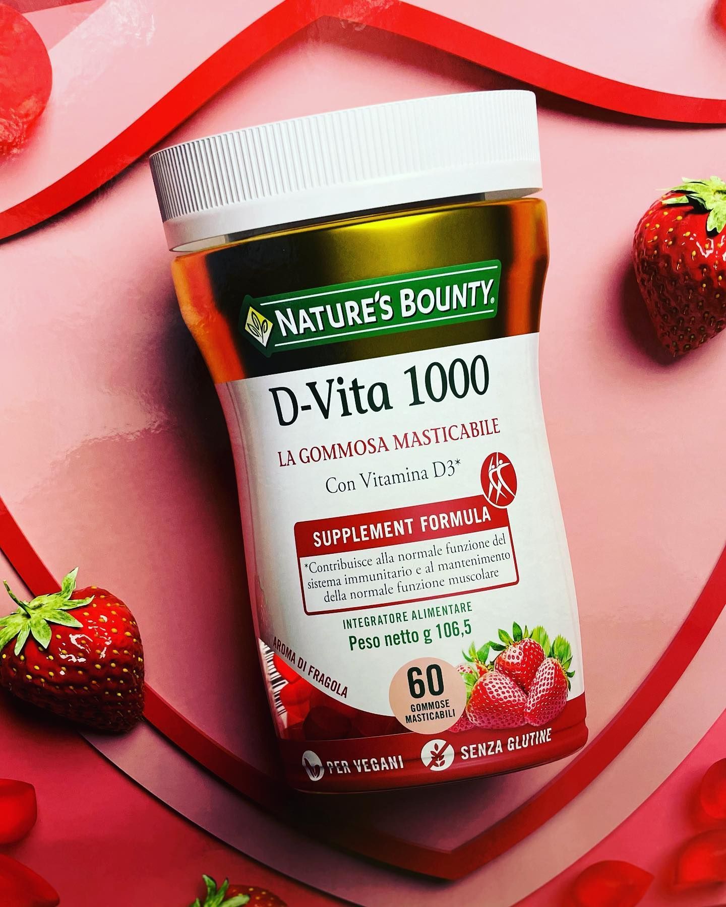 Bottiglia di caramelle gommose Nature's Bounty D-Vita 1000 con fragole su sfondo a forma di cuore rosso.