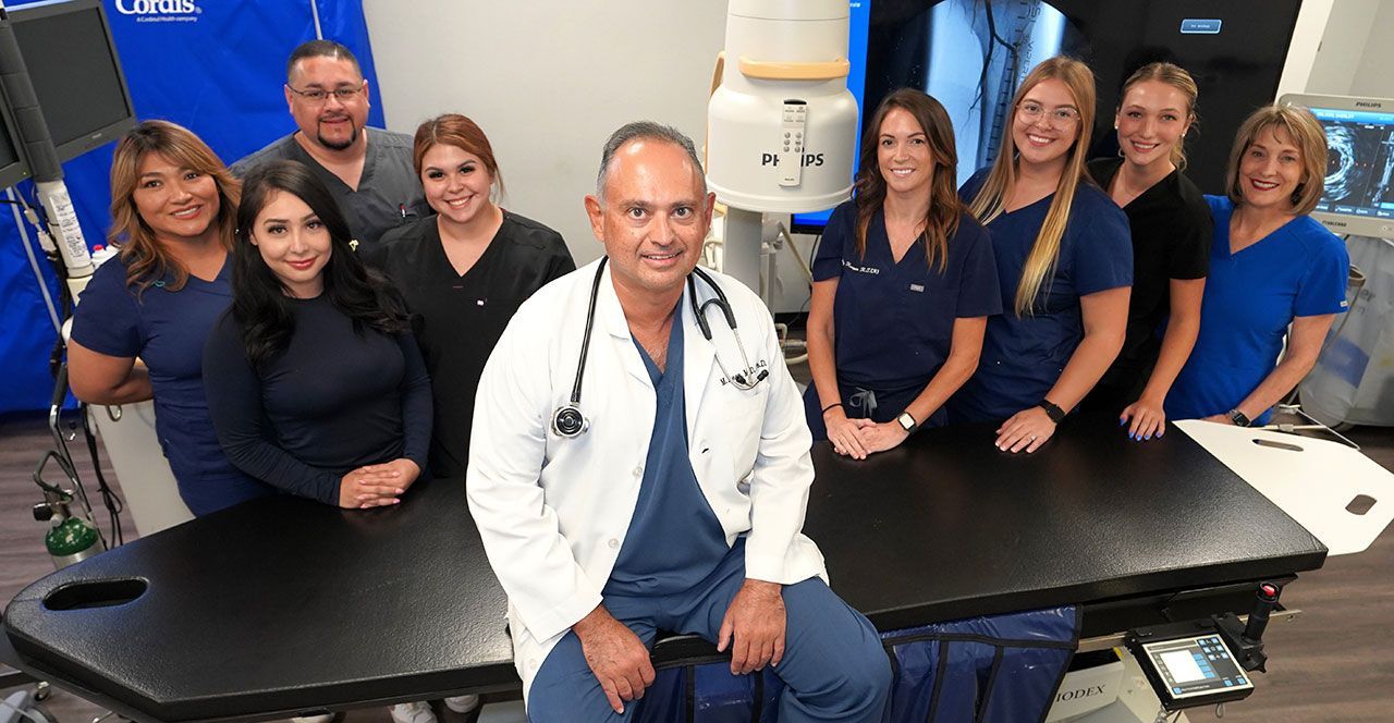 A group of doctors and nurses are posing for a picture in a hospital.