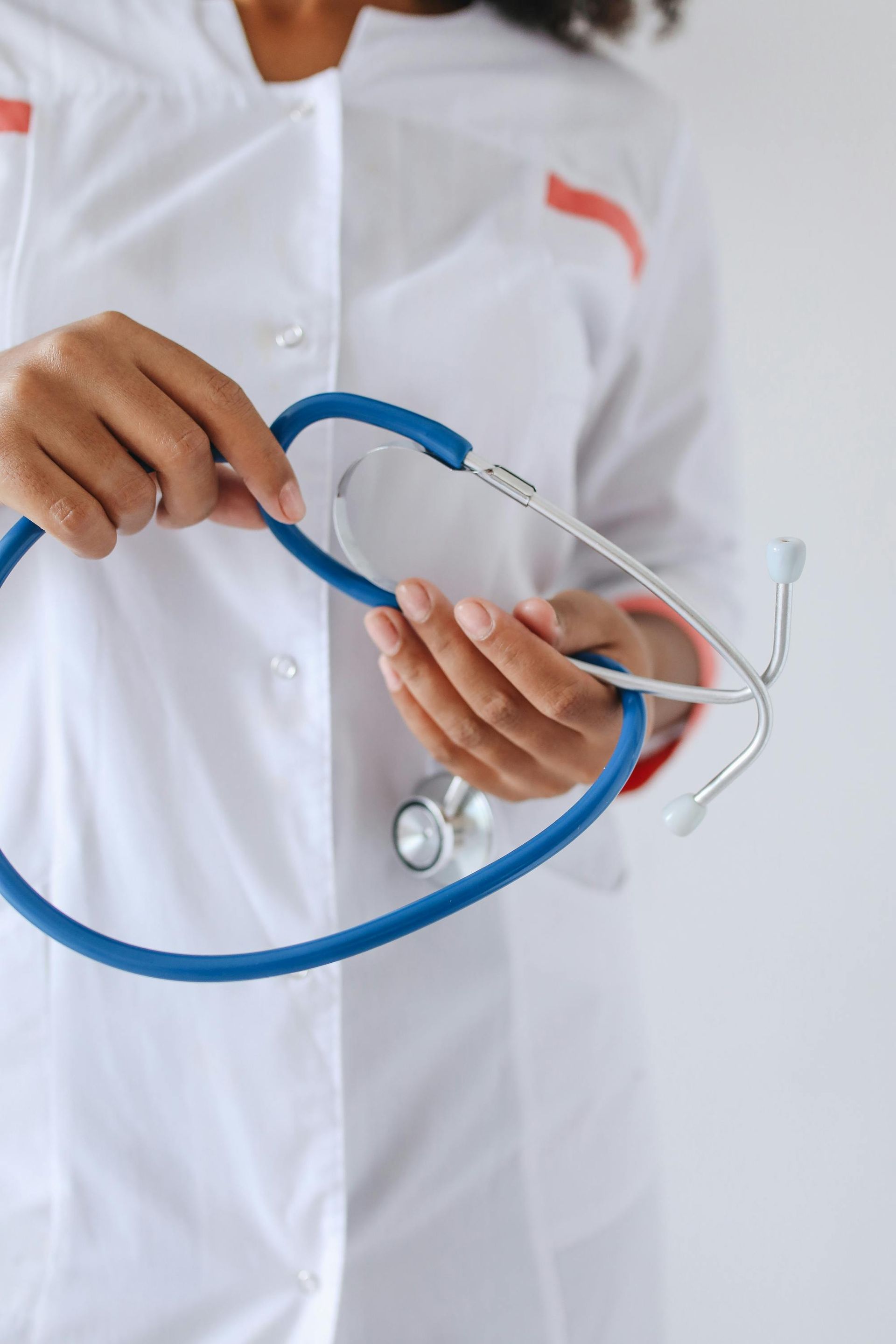 A doctor is holding a stethoscope in her hands.