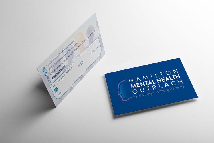 A business card for hamilton mental health outreach is sitting on a table.