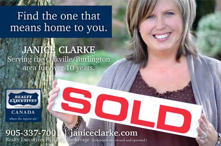 A woman is holding a sold sign in her hands