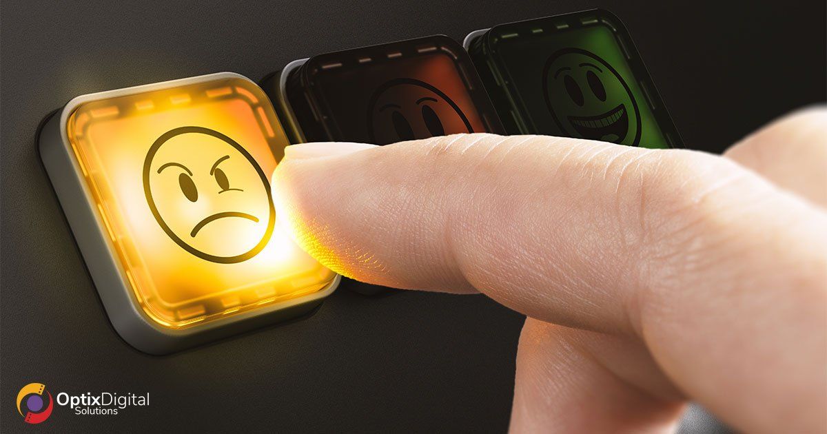finger pressing a sad face emoji button