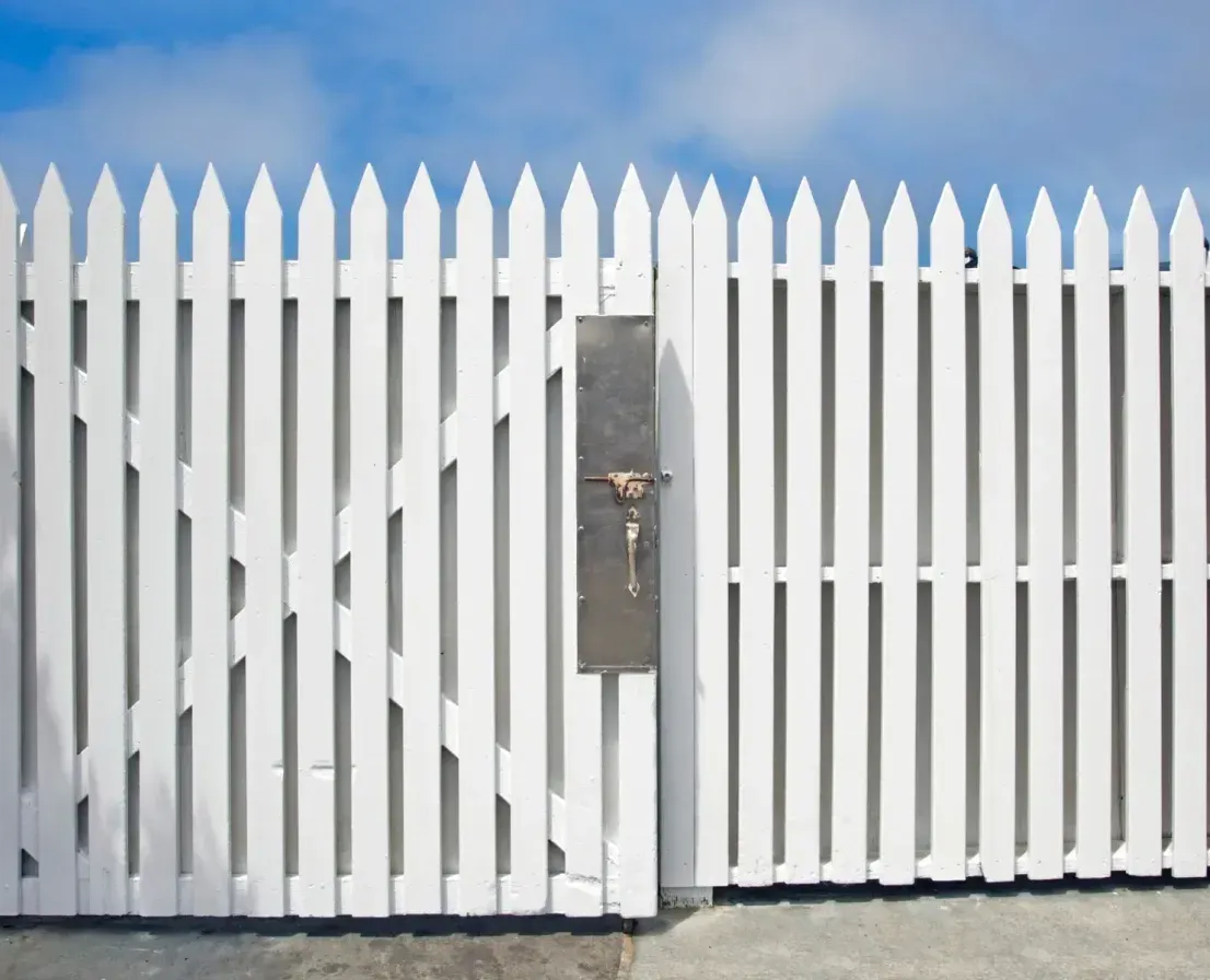 A white picket fence with a mailbox in the middle