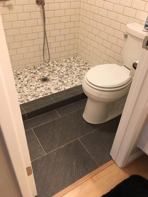 A bathroom with a toilet and a shower stall.