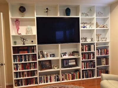A living room filled with bookshelves and a flat screen tv.