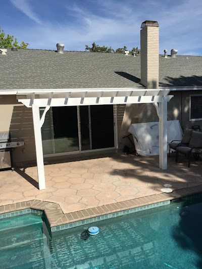 A house with a pergola over a swimming pool.