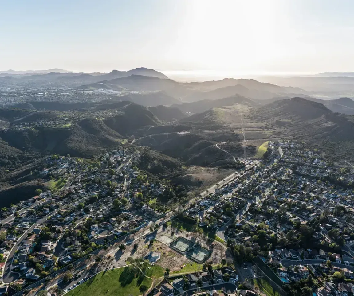 An aerial view of a city with mountains in the background.