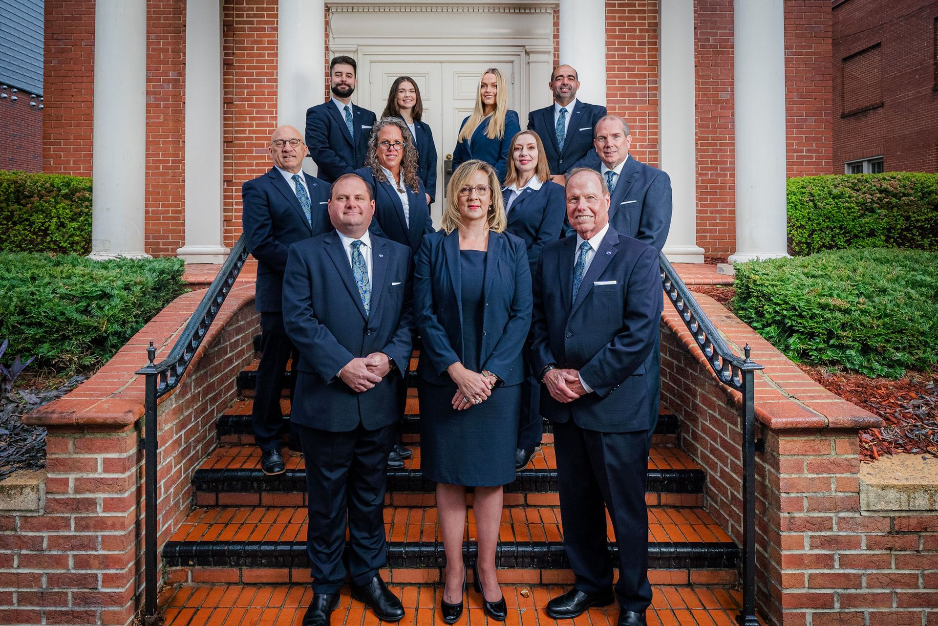 A group of people in suits and ties are posing for a picture.